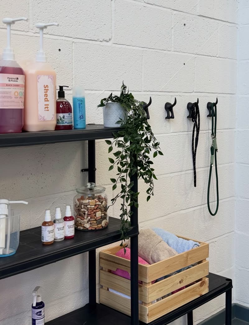 Shampoos, sprays and folded towels on the salon shelf against a white brick wall
